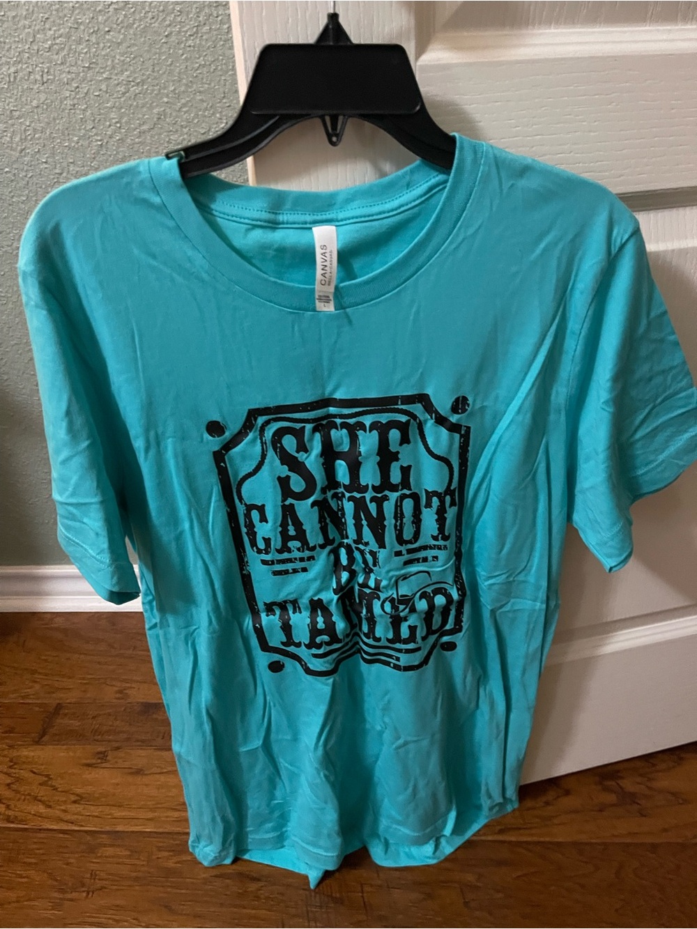 Turquoise Graphic Tee with Black 'She Cannot Be Tamed' Print